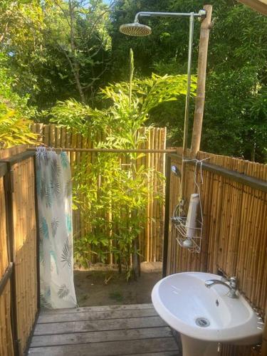 a bathroom with a sink next to a wooden fence at Safari tent with private pool close to Manuel Antonio in Matapalo