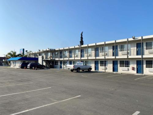 ein leerer Parkplatz vor einem großen Gebäude in der Unterkunft Motel 6-Delano, CA in Delano