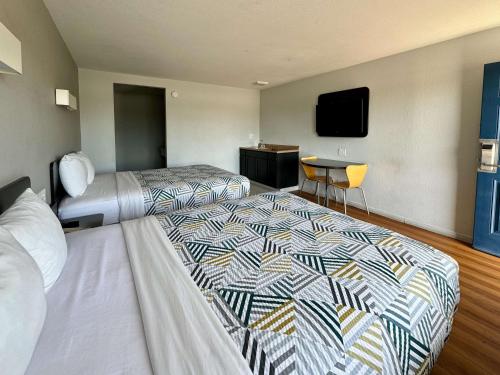 a hotel room with two beds and a flat screen tv at Motel 6-Delano, CA in Delano