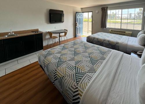 a hotel room with two beds and a sink at Motel 6-Delano, CA in Delano