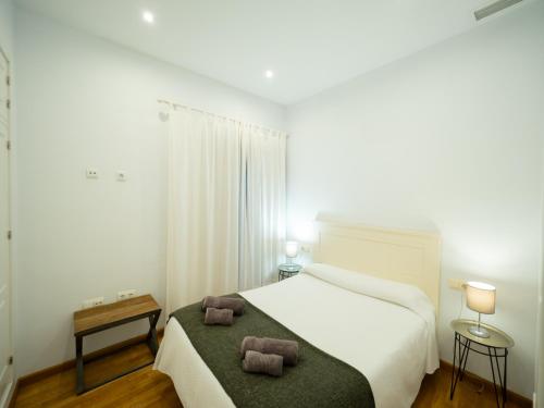 a bedroom with a bed with two pillows on it at Amplio Apto Centro vistas Torneria fjHomefj in Jerez de la Frontera
