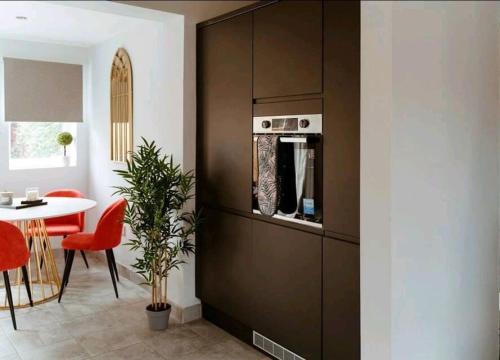 a kitchen with a microwave and a table with red chairs at Home from Home in Tyne and Wear in Westoe