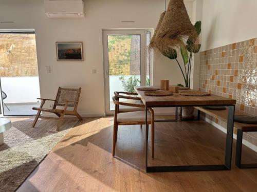 a dining room with a wooden table and chairs at Casa Aga- Cozy Seaside Apartment in Ericeira