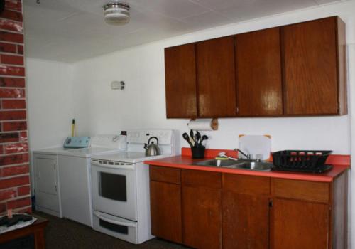 a kitchen with a white stove and a sink at Sportsman Lodge Melrose MT in Melrose
