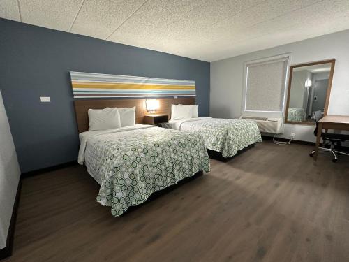 ein Hotelzimmer mit 2 Betten und einem Schreibtisch in der Unterkunft HomeTowne Studios by Red Roof Richmond, VA - W Broad St in Richmond
