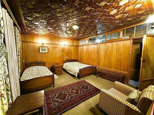 a room with two beds and a couch in it at Houseboat Lake Superior in Srinagar