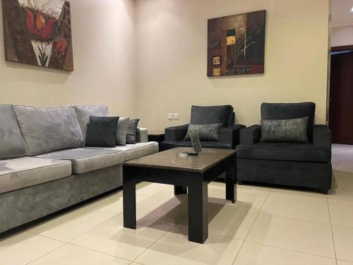 uma sala de estar com um sofá e uma mesa de centro em سكن للمسافرين em Dhamār