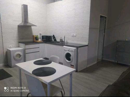 una cucina con lavatrice e tavolo di Estudio Palacio Congresos a Siviglia