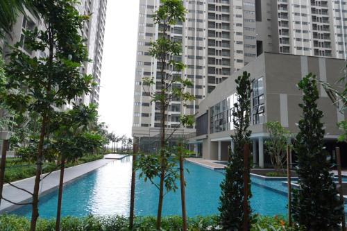 a swimming pool in an apartment complex with tall buildings at Camelia youth city nilai studio residence 5 pax. in Nilai