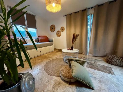 a living room with a bed and a potted plant at Maison provençale au calme de la campagne avec Jacuzzi in Aix-en-Provence