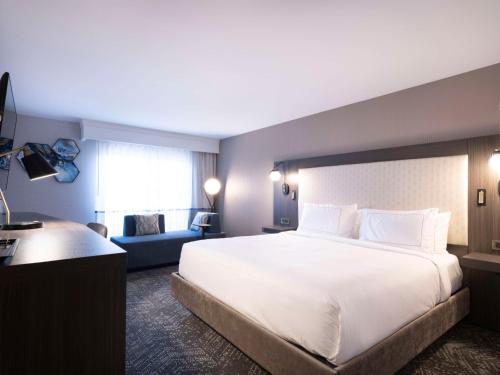 a hotel room with a large white bed and a couch at DoubleTree by Hilton Livermore, CA in Livermore