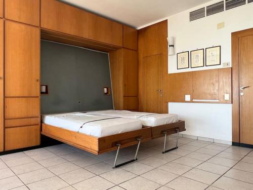Un dormitorio con una cama grande con paredes de madera. en Monolocale lido di Venezia, en Lido de Venecia