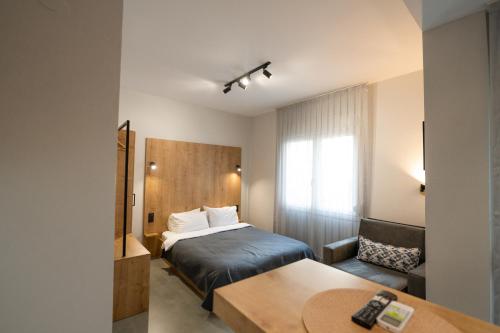 um quarto de hotel com uma cama e uma mesa em THEMIS URBAN STAY em Komotini