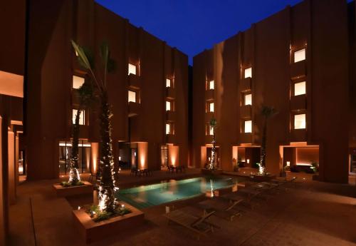 BenguerirDoubletree By Hilton Ben Guerir Hotel & Residences的带有游泳池和建筑的酒店庭院
