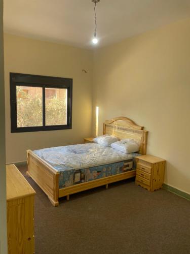 ein Schlafzimmer mit einem großen Bett und einem Fenster in der Unterkunft Azrou in Azrou
