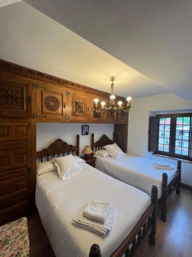 sypialnia z 2 łóżkami i żyrandolem w obiekcie Apartamento El rincón del Gato w mieście Santillana del Mar