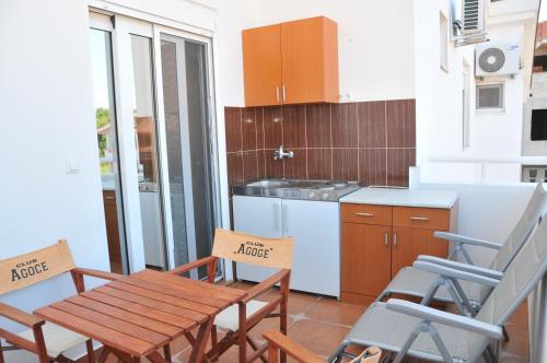 a kitchen with a wooden table and chairs in a room at Guest House Nura in Ulcinj