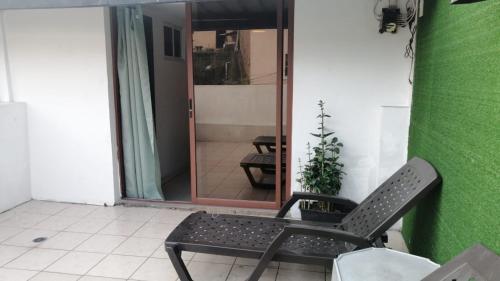 a black chair sitting in a room with a green wall at HOTEL VIEILLE MAISON in Quito