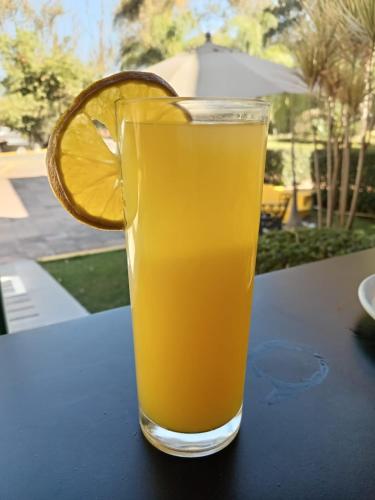 a glass of orange juice sitting on a table at HOTEL PUNTA GALERIA in Morelia