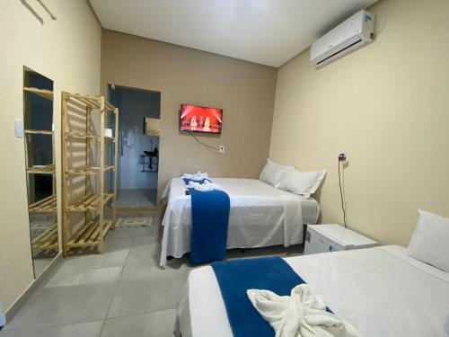 um quarto com duas camas e uma televisão na parede em Pousada Vista da Serra - Suzart em Lençóis