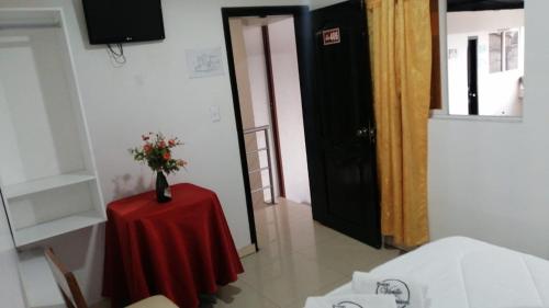 a room with a table with a vase of flowers on it at HOTEL VIEILLE MAISON in Quito