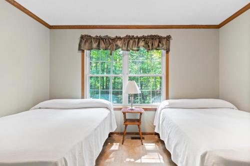 two beds in a room with a window at Lakeview on the Lake in North East