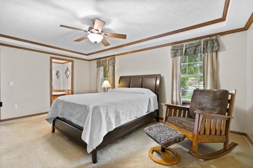 a bedroom with a bed with a ceiling fan and a chair at Lakeview on the Lake in North East