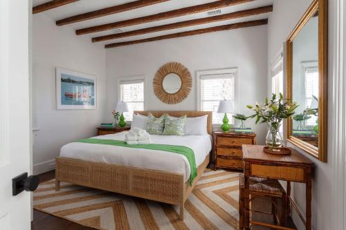 a bedroom with a large bed and a mirror at Green Cottage at Casa Zoe in Charleston