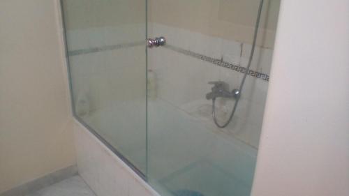 a bathroom with a shower with a glass door at Kolonaki Private Rooms in Athens