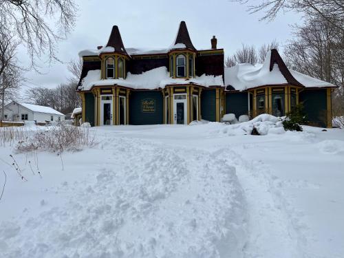 una casa cubierta de nieve delante en Belle View Manor Inn en Harbour Grace
