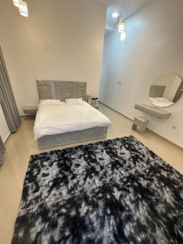 1 dormitorio con cama y alfombra negra en Cady rest, en Kalbā