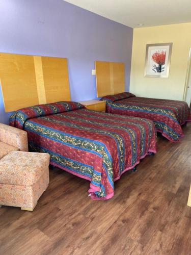 a hotel room with two beds and a couch at Relax Inn & Suites in Angleton