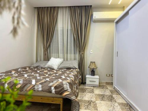 Schlafzimmer mit einem Bett und einem Fenster in der Unterkunft Exquisite Maadino in Kairo
