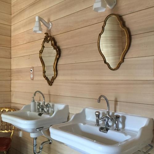 - deux lavabos dans une salle de bains avec deux miroirs sur le mur dans l'établissement Le Pavillon de l'Orangerie, à Meursanges