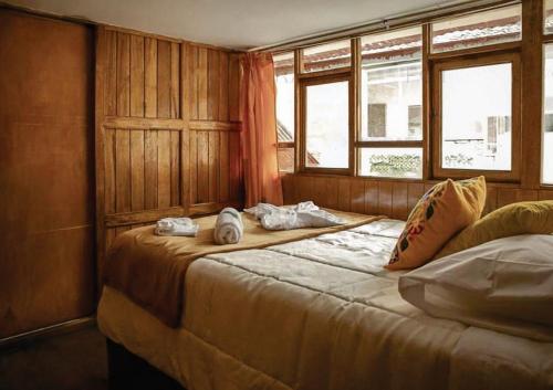 a bedroom with two beds and two windows at BEAUTIFUL, SPACIOUS & COZY HOUSE LOCATED IN THE HEART OF CUSCO in Cusco
