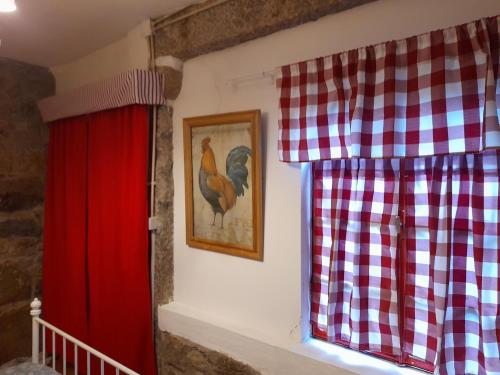 a window with a red curtain and a picture of a chicken at Quinta da Maínha - Charming Houses in Braga