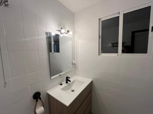a white bathroom with a sink and a mirror at CASA EL MIRADOR FIGUEROLES in Figueroles