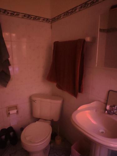 a bathroom with a toilet and a sink at Casa familiar orange corner in La Paz