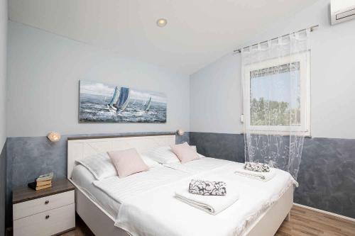 a bedroom with a large white bed with pink pillows at Holiday home in Gajana - Istrien 50093 in Gajana