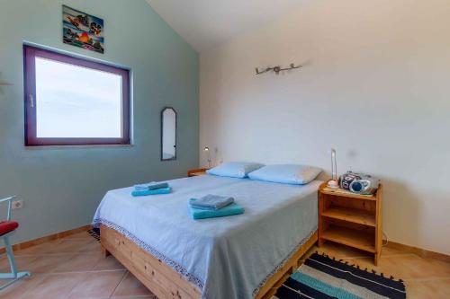 um quarto com uma cama com almofadas azuis e uma janela em Apartment in Mali Losinj 26743 em Mali Lošinj