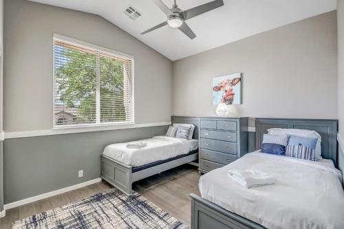 1 dormitorio con 2 camas y ventana en Pool, Putting Green, Arcade, Cornhole, Great Location at Phoenix Desert Ridge Retreat! en Phoenix