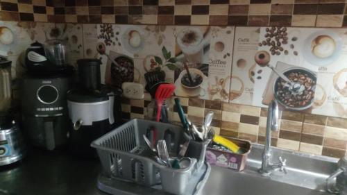 eine Küchenspüle mit Küchenutensilien in einem Geschirrregal in der Unterkunft Bed and Breakfast itagui Medellin Antioquia Colombia in Itagüí