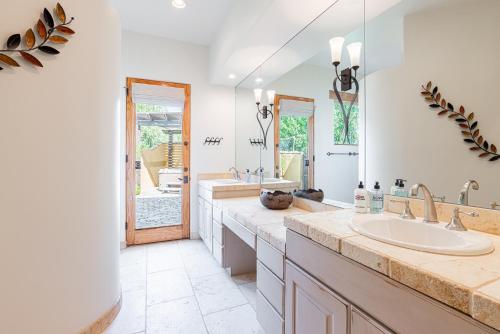 a bathroom with two sinks and a large mirror at Scottsdale Agave House- Located on one Acre, Resort Style Amenities and Private Casita! in Scottsdale