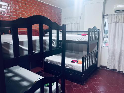 a room with two bunk beds and a brick wall at Los Guacamayos La Ceiba in La Ceiba