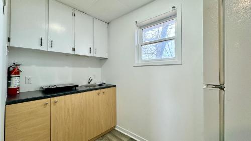 a kitchen with white cabinets and a sink and a window at SUMMERSIDE MOTEL &COTTAGES in Summerside