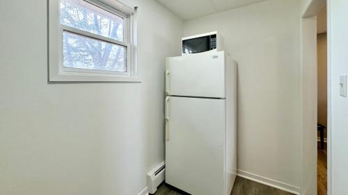 - białą lodówkę w pokoju z oknem w obiekcie SUMMERSIDE MOTEL &COTTAGES w mieście Summerside
