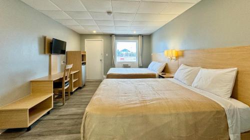 a hotel room with a large bed and a desk at SUMMERSIDE MOTEL &COTTAGES in Summerside
