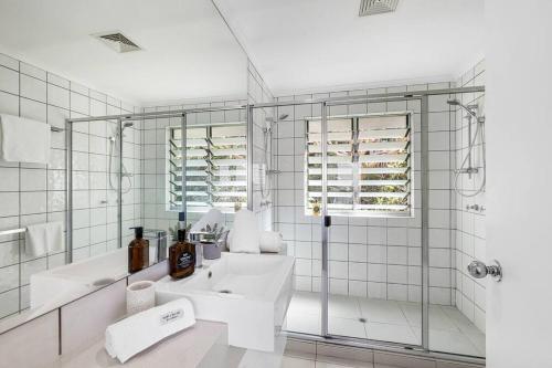 a white bathroom with a sink and a shower at 8 Andari, Sunshine Beach Luxury Beside the Beach in Sunshine Beach