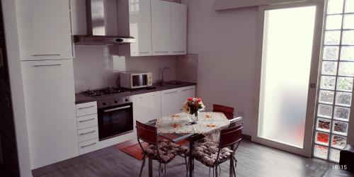 cocina con mesa con sillas y microondas en Apartment Sigaba en Milán