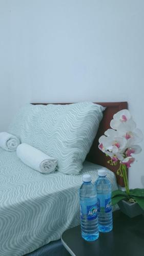 Acogedora casa en Lomas de Bella Vista في لا يونون: زجاجتان من الماء على صينية بجوار سرير